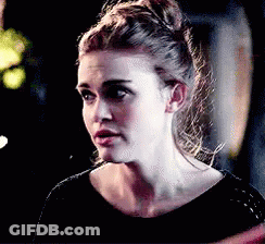 A Close Up Of A Woman 'S Face With A Bun In Her Hair . GIF