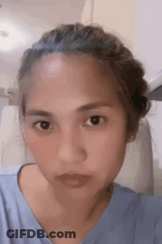 A Close Up Of A Woman 'S Face With A Bun On Her Head . GIF