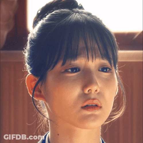 A Close Up Of A Woman 'S Face With A Bun On Her Head GIF