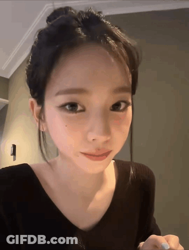 A Close Up Of A Woman 'S Face With A Bun GIF