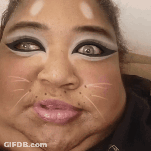 A Close Up Of A Woman 'S Face With A Cat Face Painted On It GIF