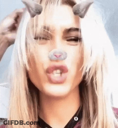 A Close Up Of A Woman 'S Face With A Cat Nose And Horns On Her Head . GIF