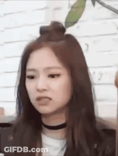 A Close Up Of A Woman 'S Face With A Choker Around Her Neck . GIF