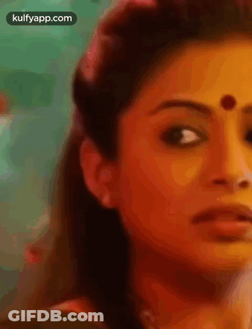 A Close Up Of A Woman 'S Face With A Dot On Her Forehead . GIF