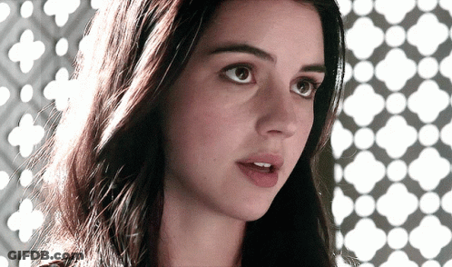 A Close Up Of A Woman 'S Face With A Geometric Pattern Behind Her GIF