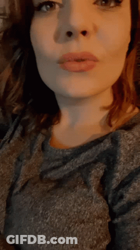 A Close Up Of A Woman 'S Face With A Gray Shirt GIF