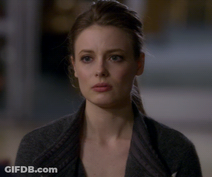 A Close Up Of A Woman 'S Face With A Gray Sweater On GIF