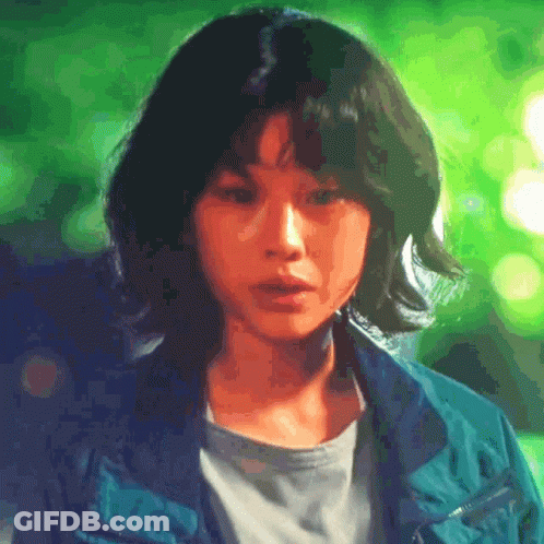 A Close Up Of A Woman 'S Face With A Green Background . GIF