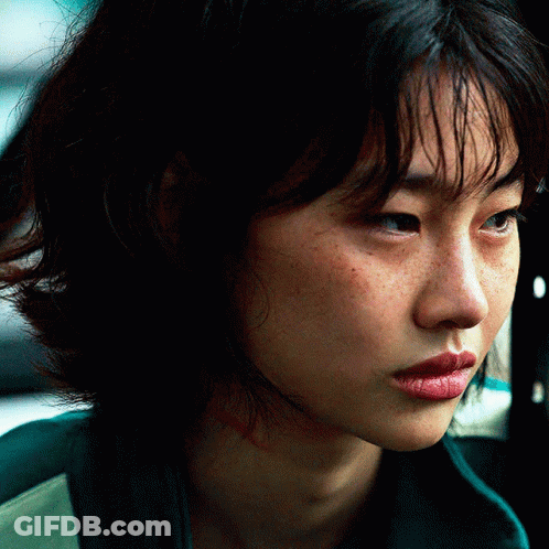 A Close Up Of A Woman 'S Face With A Green Jacket On GIF
