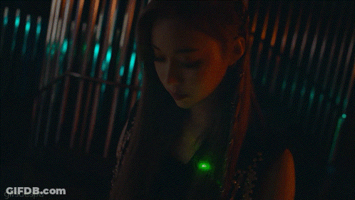 A Close Up Of A Woman 'S Face With A Green Light In Her Hair GIF