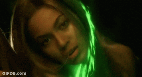 A Close Up Of A Woman 'S Face With A Green Light Shining On It . GIF