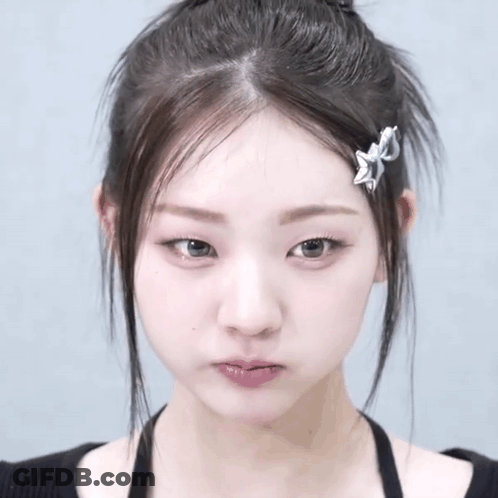 A Close Up Of A Woman 'S Face With A Hair Clip On Her Hair GIF