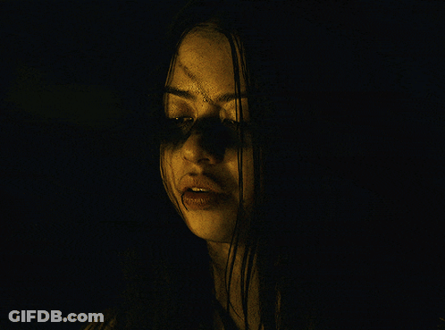 A Close Up Of A Woman 'S Face With A Hand Covering Her Mouth GIF
