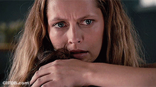 A Close Up Of A Woman 'S Face With A Hand On Her Face GIF