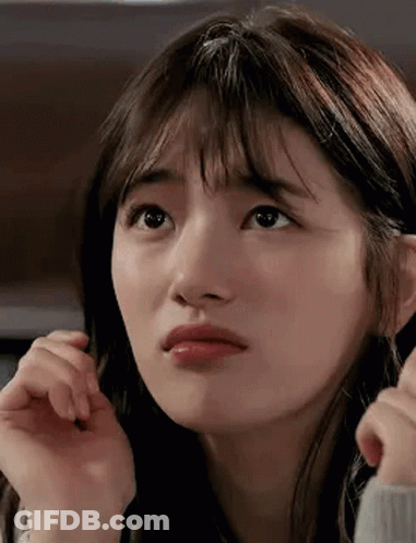 A Close Up Of A Woman 'S Face With A Hand On Her Face . GIF