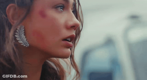A Close Up Of A Woman 'S Face With A Leaf Earring GIF