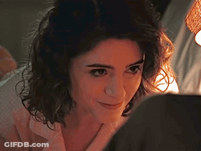 A Close Up Of A Woman 'S Face With A Light Shining On Her Face . GIF