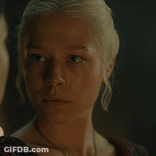 A Close Up Of A Woman 'S Face With A Man In The Background GIF