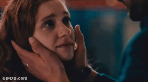 A Close Up Of A Woman 'S Face With A Man 'S Hand Touching It GIF