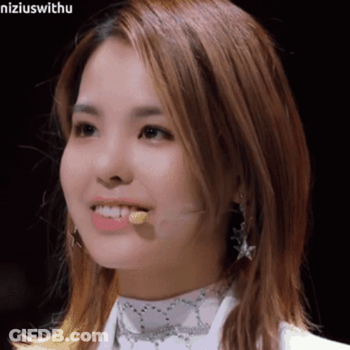 A Close Up Of A Woman 'S Face With A Microphone Sticking Out Of Her Mouth . GIF