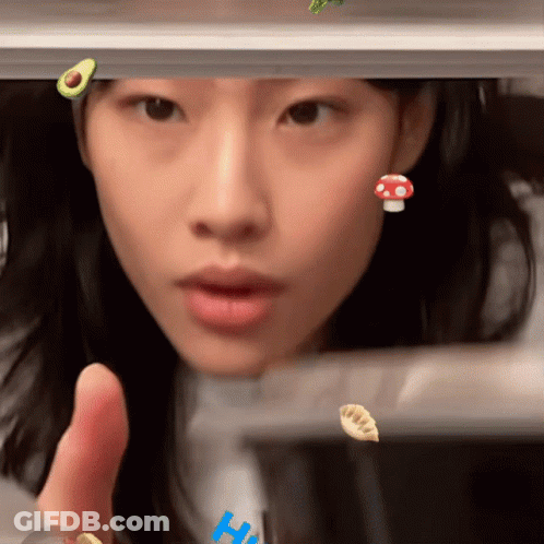 A Close Up Of A Woman 'S Face With A Mushroom And An Avocado On Her Head GIF