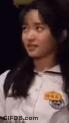 A Close Up Of A Woman 'S Face With A Name Tag On Her Chest GIF