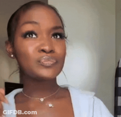 A Close Up Of A Woman 'S Face With A Necklace And Earrings . GIF