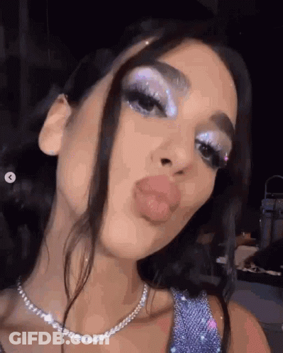 A Close Up Of A Woman 'S Face With A Necklace And Makeup On . GIF