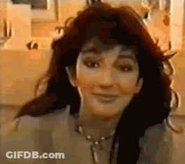A Close Up Of A Woman 'S Face With A Necklace Around Her Neck . GIF
