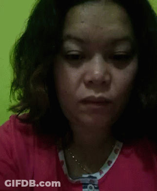 A Close Up Of A Woman 'S Face With A Necklace Around Her Neck . GIF