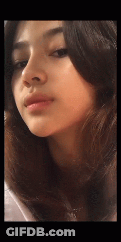 A Close Up Of A Woman 'S Face With A Necklace Around Her Neck GIF