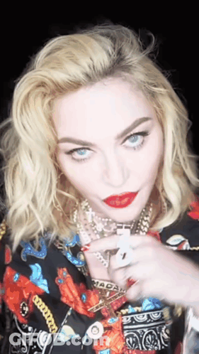 A Close Up Of A Woman 'S Face With A Necklace That Says Macau On It GIF