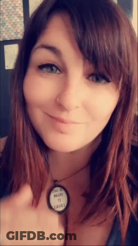 A Close Up Of A Woman 'S Face With A Necklace That Says ' Made In Usa ' On It GIF