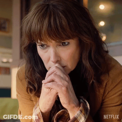 A Close Up Of A Woman 'S Face With A Netflix Logo In The Background GIF