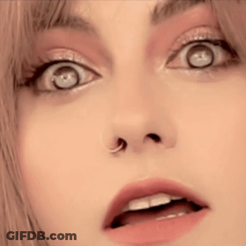 A Close Up Of A Woman 'S Face With A Nose Ring And A Surprised Look On Her Face . GIF