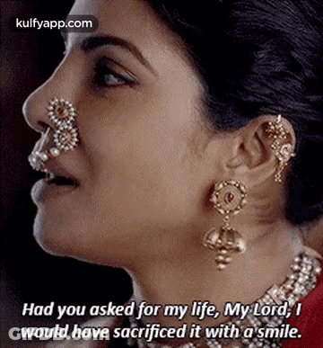 A Close Up Of A Woman 'S Face With A Nose Ring And Earrings And A Quote . GIF