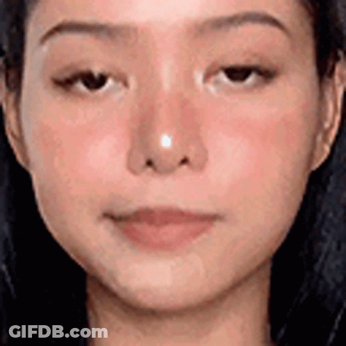 A Close Up Of A Woman 'S Face With A Nose Ring On It . GIF
