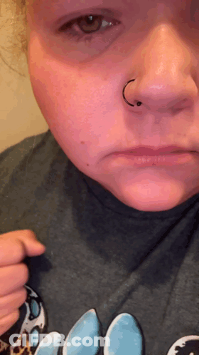 A Close Up Of A Woman 'S Face With A Nose Ring On It GIF