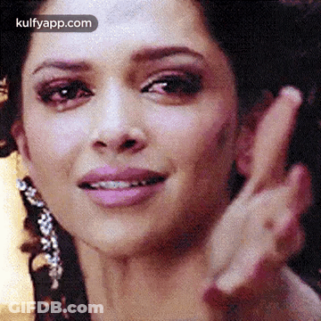 A Close Up Of A Woman 'S Face With A Peace Sign . GIF
