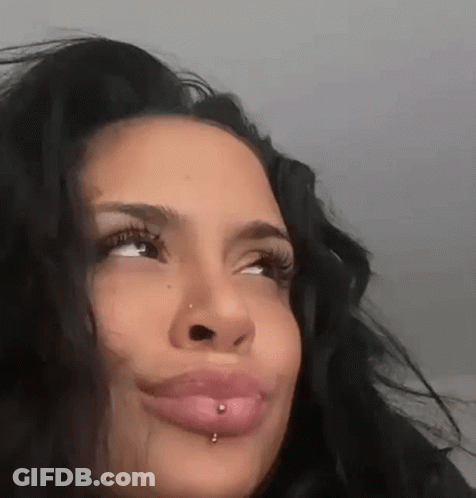 A Close Up Of A Woman 'S Face With A Piercing In Her Lip And Nose . GIF