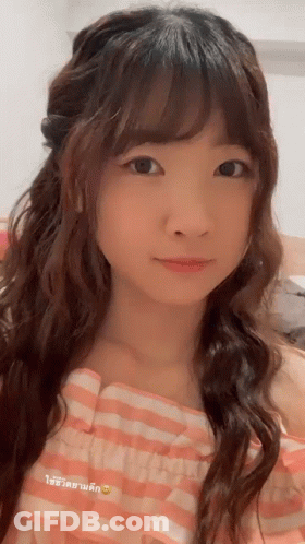 A Close Up Of A Woman 'S Face With A Pink And White Checkered Shirt GIF