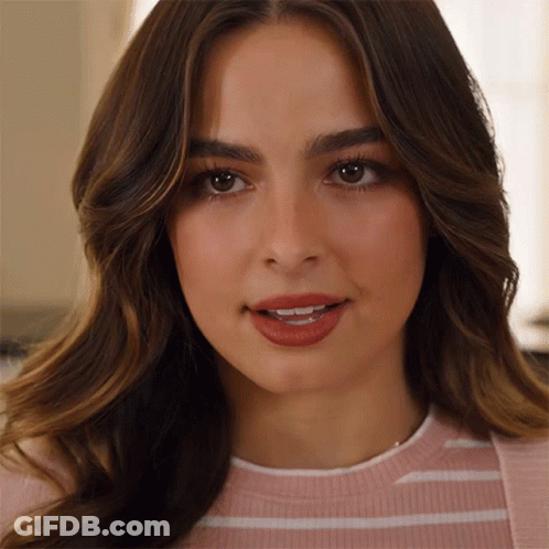 A Close Up Of A Woman 'S Face With A Pink And White Striped Shirt On GIF