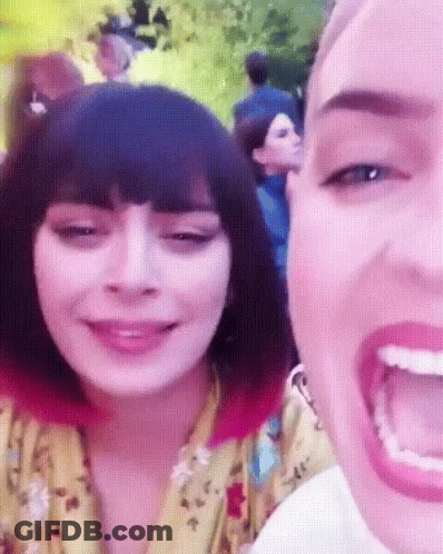 A Close Up Of A Woman 'S Face With A Pink Background GIF