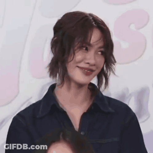 A Close Up Of A Woman 'S Face With A Pink Background GIF