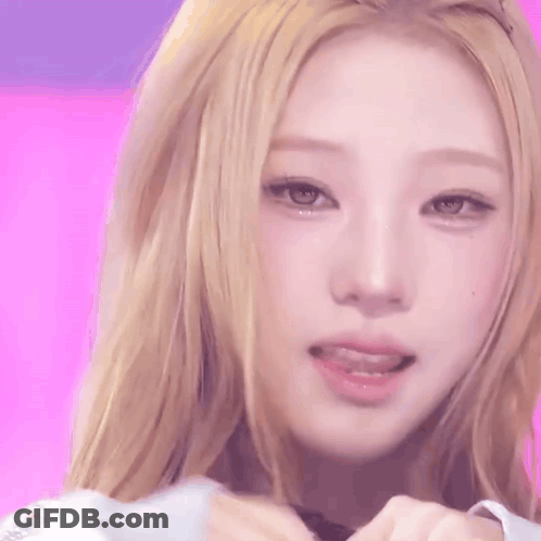 A Close Up Of A Woman 'S Face With A Pink Background . GIF