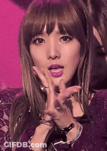 A Close Up Of A Woman 'S Face With A Pink Background . GIF