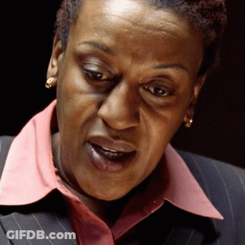 A Close Up Of A Woman 'S Face With A Pink Collar And Earrings GIF