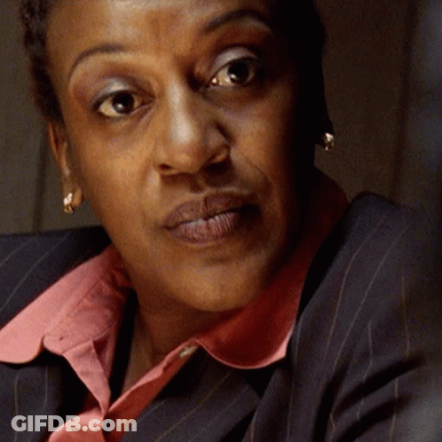 A Close Up Of A Woman 'S Face With A Pink Collar And Earrings GIF
