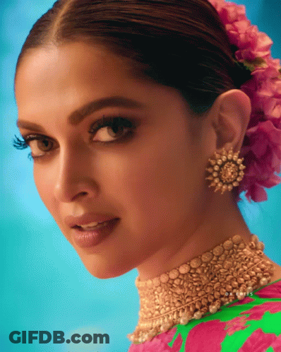 A Close Up Of A Woman 'S Face With A Pink Flower In Her Hair And The Name Dr. Louis On The Bottom GIF