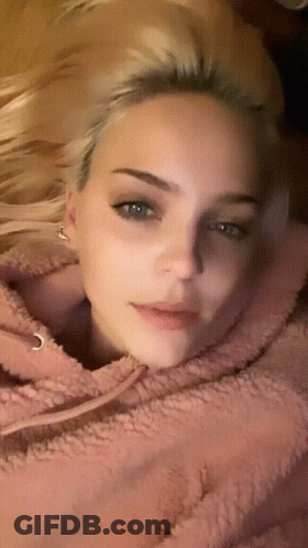A Close Up Of A Woman 'S Face With A Pink Hoodie On GIF